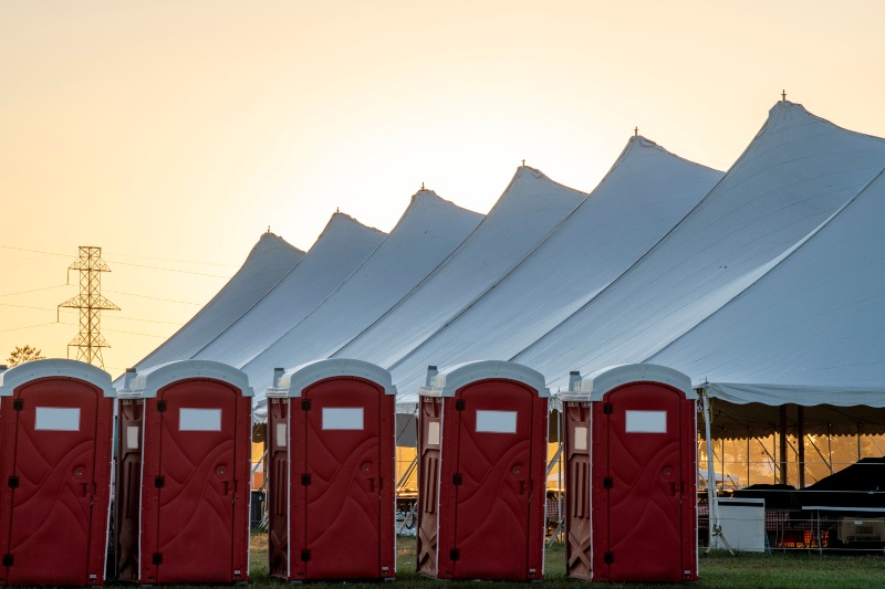 Portable Toilets Beside an Outdoor Event Tent in South Jersey Offering Restroom Access to Attendees