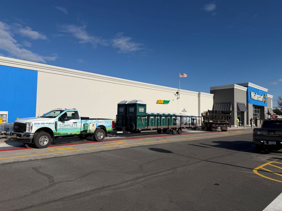 Portable toilet rental trailer and service truck staged outside Walmart store in Mantua, NJ