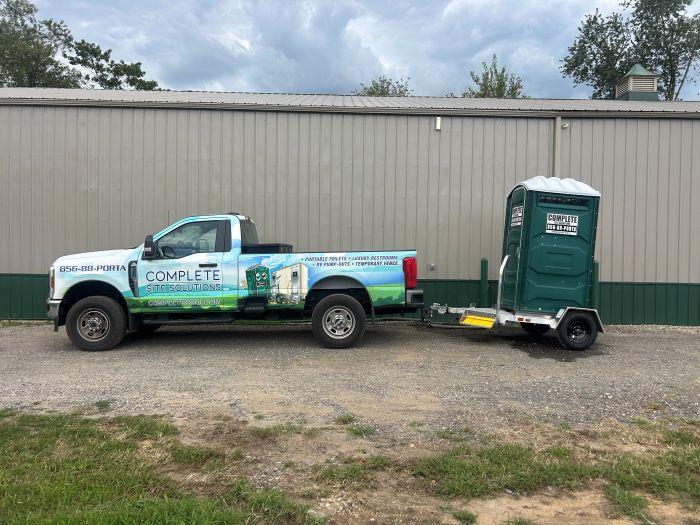Portable toilet trailer attached to service truck outside a site in Mullica Hill, NJ